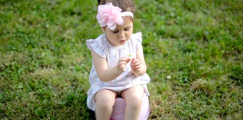 Child sitting on a potty on the grass